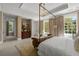 Elegantly furnished primary bedroom with a four-poster bed, chandelier, and an abundance of natural light at 8 W Andrews Nw Dr, Atlanta, GA 30305