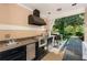 Outdoor kitchen under a covered area is equipped with a sink, grill and cabinets at 8 W Andrews Nw Dr, Atlanta, GA 30305