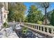 Relaxing stone patio with views of lush greenery and a classic white railing at 8 W Andrews Nw Dr, Atlanta, GA 30305