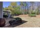 Well-maintained backyard features a patio area with seating, a spacious lawn, mature trees, and a privacy fence at 1037 Dunedin Trl, Woodstock, GA 30188