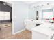 Bright bathroom featuring a double sink vanity, large mirror with Hollywood lights, and access to a large bedroom at 1037 Dunedin Trl, Woodstock, GA 30188