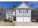 Charming two-story home with a two-car garage and well-maintained front yard at 1037 Dunedin Trl, Woodstock, GA 30188