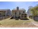 Back exterior view of the house showcasing a sunroom extension, backyard, and neighboring houses at 1037 Dunedin Trl, Woodstock, GA 30188