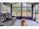 Bright sunroom features large windows overlooking the private backyard, and comfortable seating for relaxation at 1037 Dunedin Trl, Woodstock, GA 30188