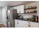 Kitchen featuring stainless steel refrigerator, wooden open shelves, and white cabinetry at 2189 Gordon Se Cir, Smyrna, GA 30080