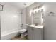 Modern bathroom features white tile and gray vanity with stylish lighting fixture at 1027 Garibaldi Sw St, Atlanta, GA 30310