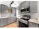 Updated kitchen with white countertops, grey cabinets, stainless appliances and track lighting at 1027 Garibaldi Sw St, Atlanta, GA 30310