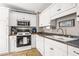 Bright kitchen with white cabinets, modern appliances, plenty of counter space, and tile flooring at 1257 Lyle Pl, Atlanta, GA 30318