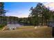 Backyard view at dusk showcasing a lake and a inviting fire pit with chairs at 1861 Poplar Falls Ave, Lithonia, GA 30058