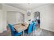 Tasteful dining area with gray floors is bathed in natural light and features blue upholstered chairs at 1861 Poplar Falls Ave, Lithonia, GA 30058