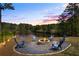Backyard fire pit at dusk with seating around a lake at 1861 Poplar Falls Ave, Lithonia, GA 30058