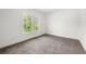 Bright bedroom featuring neutral carpeting, white walls, and a view of lush greenery at 2869 4Th Sw St, Atlanta, GA 30315
