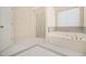 Spacious bathroom with tiled flooring, shower, and a luxurious soaking tub with marble accents at 4355 Rainer Dr, Atlanta, GA 30349