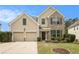 Two-story home featuring a blend of siding and brick, complemented by a well-manicured lawn and a two-car garage at 4355 Rainer Dr, Atlanta, GA 30349