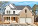 Charming two-story home featuring a brick facade, white siding, and a two-car garage at 4444 Sullivan Rd, Powder Springs, GA 30127