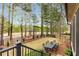 Picturesque backyard with an iron fence, dining area, manicured lawn, and views of the wooded surroundings at 145 Cuthbert Ln, Acworth, GA 30101