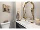 Stylish powder room featuring designer mirror, marble countertop, elegant fixtures, and a decorative painting at 145 Cuthbert Ln, Acworth, GA 30101