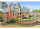 An impressive red brick home boasts manicured landscaping, a turret, and arched windows at 145 Cuthbert Ln, Acworth, GA 30101