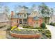 Stunning red brick home showcases impeccable landscaping, a turret, and a welcoming front porch at 145 Cuthbert Ln, Acworth, GA 30101