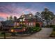 Stunning brick home with manicured landscaping and a circular driveway at dusk at 145 Cuthbert Ln, Acworth, GA 30101