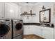 Well-equipped laundry room with modern washer/dryer, granite countertop, ample storage, and stylish decor at 145 Cuthbert Ln, Acworth, GA 30101
