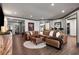 Spacious living room with a large leather sectional and hardwood floors, with an ottoman in front at 145 Cuthbert Ln, Acworth, GA 30101