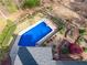 Aerial view of a sparkling blue swimming pool surrounded by lush landscaping and a wooden pergola at 2121 Rock Court, Loganville, GA 30052