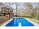 Backyard swimming pool surrounded by greenery, with deck, fence, and ladder at 2121 Rock Court, Loganville, GA 30052