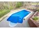 Aerial view of backyard pool with diving board and concrete deck with brick fence at 2121 Rock Court, Loganville, GA 30052