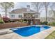Large swimming pool with diving board and backyard deck on two-story home with manicured landscape at 2121 Rock Court, Loganville, GA 30052