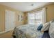 Bright bedroom featuring neutral walls and bedding with blue accents and a sunny window at 2121 Rock Court, Loganville, GA 30052