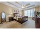 Serene bedroom featuring a tray ceiling, a ceiling fan, a large window and neutral carpeting at 2121 Rock Court, Loganville, GA 30052