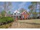Attractive two-story brick home with a large lawn, landscaping, and mature trees at 2121 Rock Court, Loganville, GA 30052