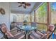 Outdoor porch with seating area, ceiling fan, and a tranquil view of a wooded backyard at 2121 Rock Court, Loganville, GA 30052