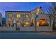 Stunning stone home featuring elegant arched entryway and upper level balcony, all illuminated by warm lighting at 165 2Nd St, Fayetteville, GA 30214