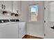 Well-lit laundry room featuring white cabinets and modern washer and dryer units at 165 2Nd St, Fayetteville, GA 30214