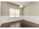 Well-lit dining area with wainscoting, hardwood floors, and a large window offering natural light at 245 Astoria Way, Mcdonough, GA 30253