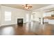 Cozy living room with fireplace, hardwood floors, open to kitchen with breakfast bar and neutral paint at 245 Astoria Way, Mcdonough, GA 30253