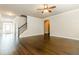 Spacious living room featuring hardwood floors and staircase, with neutral paint and a ceiling fan at 245 Astoria Way, Mcdonough, GA 30253