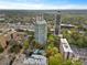 Aerial view of community featuring a pool, surrounded by mature trees and greenery, with city views at 2870 Pharr Court South Nw # 504, Atlanta, GA 30305