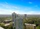 Aerial view of high-rise apartments surrounded by lush trees and foliage, and a cityscape in the background at 2870 Pharr Court South Nw # 504, Atlanta, GA 30305