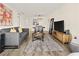 Bright living room with modern gray sofa, wooden floors, and view into dining area at 2870 Pharr Court South Nw # 504, Atlanta, GA 30305