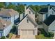 An aerial view of a home featuring a two-car garage and surrounded by mature trees and landscaping at 4124 Hunt St, Covington, GA 30014