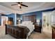 Spacious main bedroom with a wooden bed frame, blue accent wall, and open doorway at 4124 Hunt St, Covington, GA 30014
