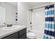 Bathroom featuring a single sink vanity, walk in shower with a striped curtain, white walls and tile floors at 4133 Shoals Ln, Union City, GA 30291