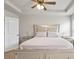 Bright primary bedroom with a tray ceiling, ceiling fan, and large bed with silver accents at 4133 Shoals Ln, Union City, GA 30291
