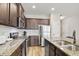 Modern kitchen boasting stainless steel appliances, granite countertops, and dark wood cabinets at 4133 Shoals Ln, Union City, GA 30291