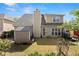 Spacious backyard featuring lush grass, mature trees, tan siding and a large storage shed at 847 Edgeley Ln, Lawrenceville, GA 30044