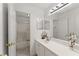 Well-lit bathroom with a shower-tub combo, white vanity, decorative mirror and chrome fixtures at 847 Edgeley Ln, Lawrenceville, GA 30044