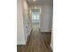 Bright hallway featuring hardwood floors, white walls, and access to various rooms at 89 Mayhaw Pt, Sharpsburg, GA 30277